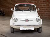 a small white car parked in front of a brick wall