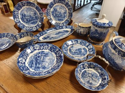 des assiettes, tasses et soucoupes bleues et blanches posées sur une table en bois
