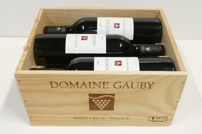 trois bouteilles de vin dans un coffret en bois sur une table