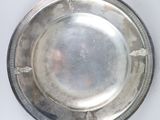 an antique silver plate on a white background with a silver rim