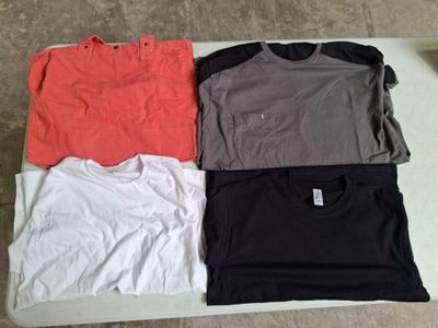 three t - shirts are sitting on a table in a row