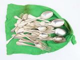 a lot of spoons and spoon spoons on a green cloth
