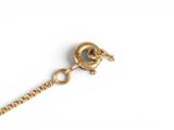a close up of a gold chain with a ball on it