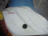 un objet en porcelaine blanche sur lequel figure un point noir
