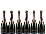 six bottles of champagne lined up against a white background