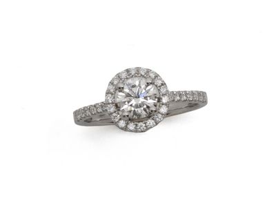 une bague en or blanc sertie d'un diamant central entouré de diamants