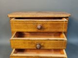 an image of a small wooden drawer with three drawers
