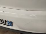 a close up of a white car with a number plate on it