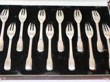 six forks in a case that are in the shape of forks