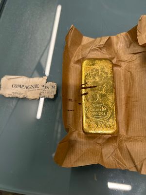 a gold bar on a piece of paper on a glass table