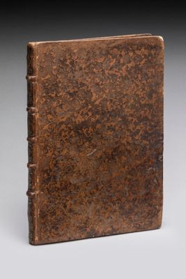 un vieux livre à la couverture brune posé sur une table