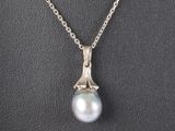 un pendentif en perles blanches et diamants sur une chaîne en argent