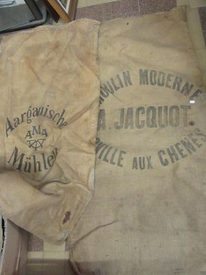 un sac de farine posé par terre à côté d'un poêle