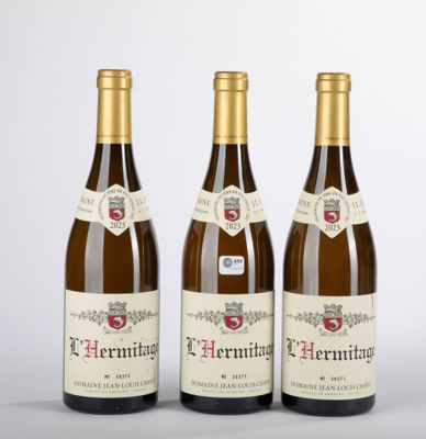 trois bouteilles de vin posées sur une table blanche