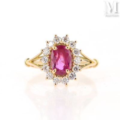 a close up of a pink sapphire and diamond ring on a white surface