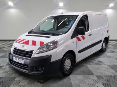 la camionnette blanche est garée sur un sol en damier dans le garage