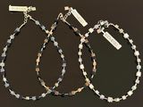 two pairs of black and white beaded bracelets with tags on them