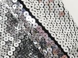 black and silver sequinized fabric with circles on it