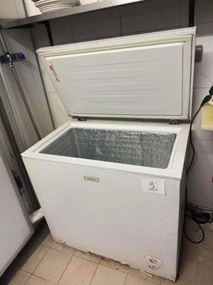 un congélateur coffre blanc posé dans un coin de la cuisine