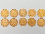 un tas de pièces d'or posé sur une surface blanche