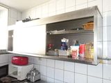 une cuisine équipée d'une cuisinière, d'un micro-ondes et d'autres ustensiles posés sur le plan de travail