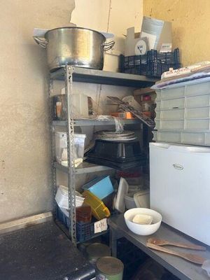 a small kitchen with a stove, microwave and other items on the shelves
