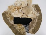 a hat made out of old clothes on a white surface