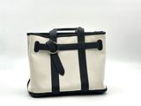 a white and black tote bag sitting on top of a white table