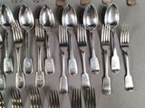 a lot of silver spoons and forks on the table