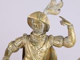 a gold statue of a man with a feather on his head
