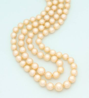 a close up of a strand of pearls on a white surface