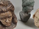 three busts of people sitting next to each other on a table