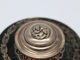 an image of a close up of a metal object on a white surface