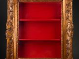 an antique wooden bookcase with a red book shelf in the middle