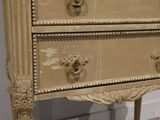 a small chest of drawers with gold knobs on it