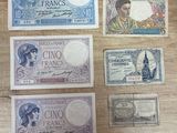 six billets de banque français différents posés sur une table au plateau en bois