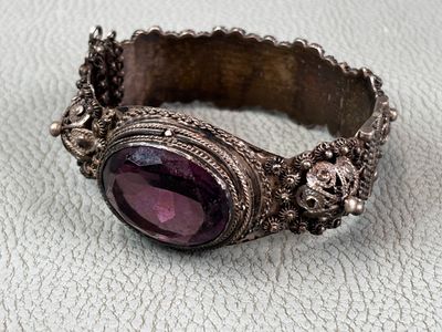 une image représentant un bracelet en argent orné d'une pierre violette au centre