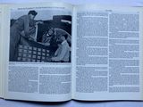 an open book with a picture of two men working on a machine