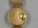 a close up of a gold bracelet with a fish on it