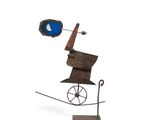 sculpture représentant un homme à vélo, coiffé d'un chapeau bleu