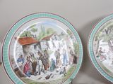 two plates with a picture of a village scene on them