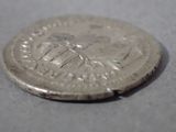 a silver coin on a table with a white background