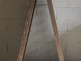 a wooden triangle that is leaning against a brick wall