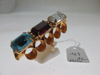 une image représentant une bague en or sertie d'une pierre bleue et verte