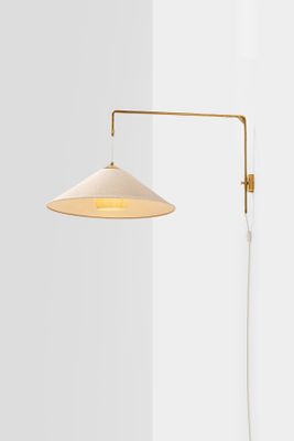 a white lamp on a wall next to a white wall
