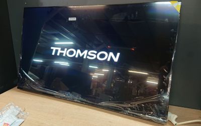 a television sitting on a table with a remote in front of it
