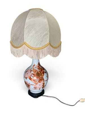 une lampe munie d'un abat-jour blanc