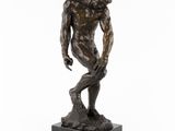 une statue en bronze représentant un homme debout sur un socle en marbre