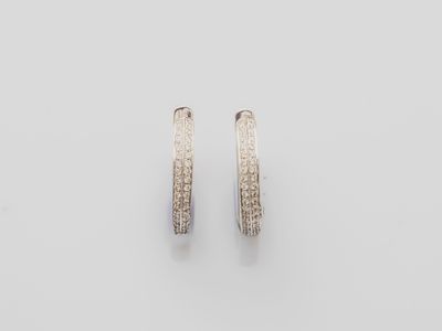 a pair of white gold hoop earrings on a white background