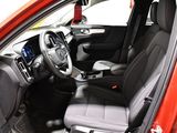 the interior of a red car with a steering wheel and dashboard